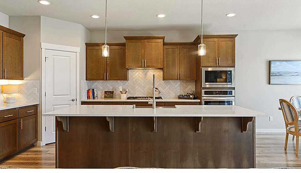 Open kitchen with quartz island and stainless steel appliances
