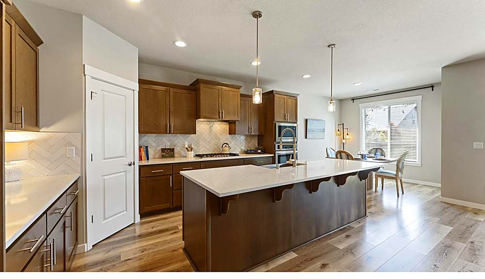 Open kitchen with quartz island and stainless steel appliances