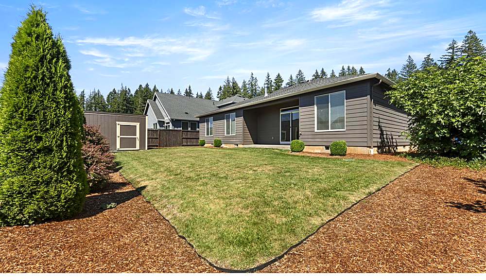 Fenced backyard with lawn and sprinklers