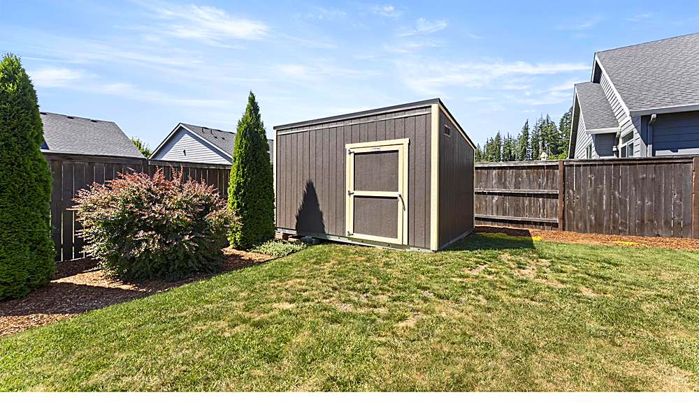 Fenced backyard with lawn and sprinklers